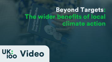 "Beyond Targets conference graphic showing UK100 logo and title 'Beyond Targets: The wider benefits of local climate action' with blurred conference attendee in background"