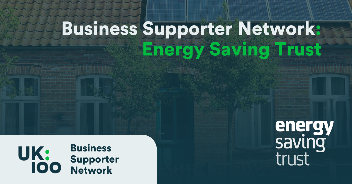 UK100 Business Supporter Network banner featuring Energy Saving Trust logo against a background of residential buildings with solar panels on rooftops